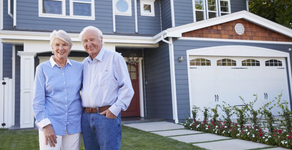 Seniors in front of a blue house